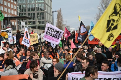 Viele Menschen halten Fahnen und Schilder auf einer Demo gegen fossile Subventionen